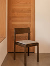 Mauro Seat Cushion by Audo styled on a dark-stained dining chair in a calm timber interior – In Dubai by WSPR