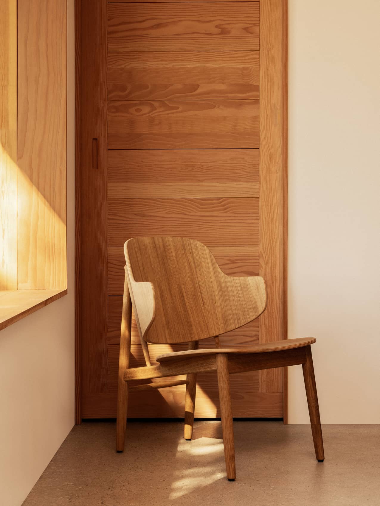 Penguin Wooden Lounge Chair by Audo styled beside a sunlit window and timber door – In Dubai by WSPR