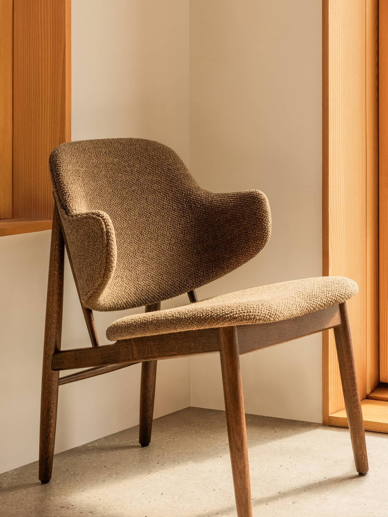 Penguin Wooden Lounge Chair by Audo, fully upholstered, styled in a warm corner by a window – In Dubai by WSPR