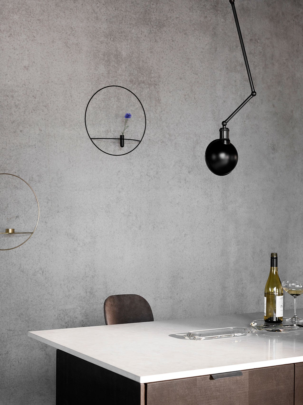 Hudson Wall/Ceiling Lamp by Audo styled above a marble table against a concrete wall – In Dubai by WSPR