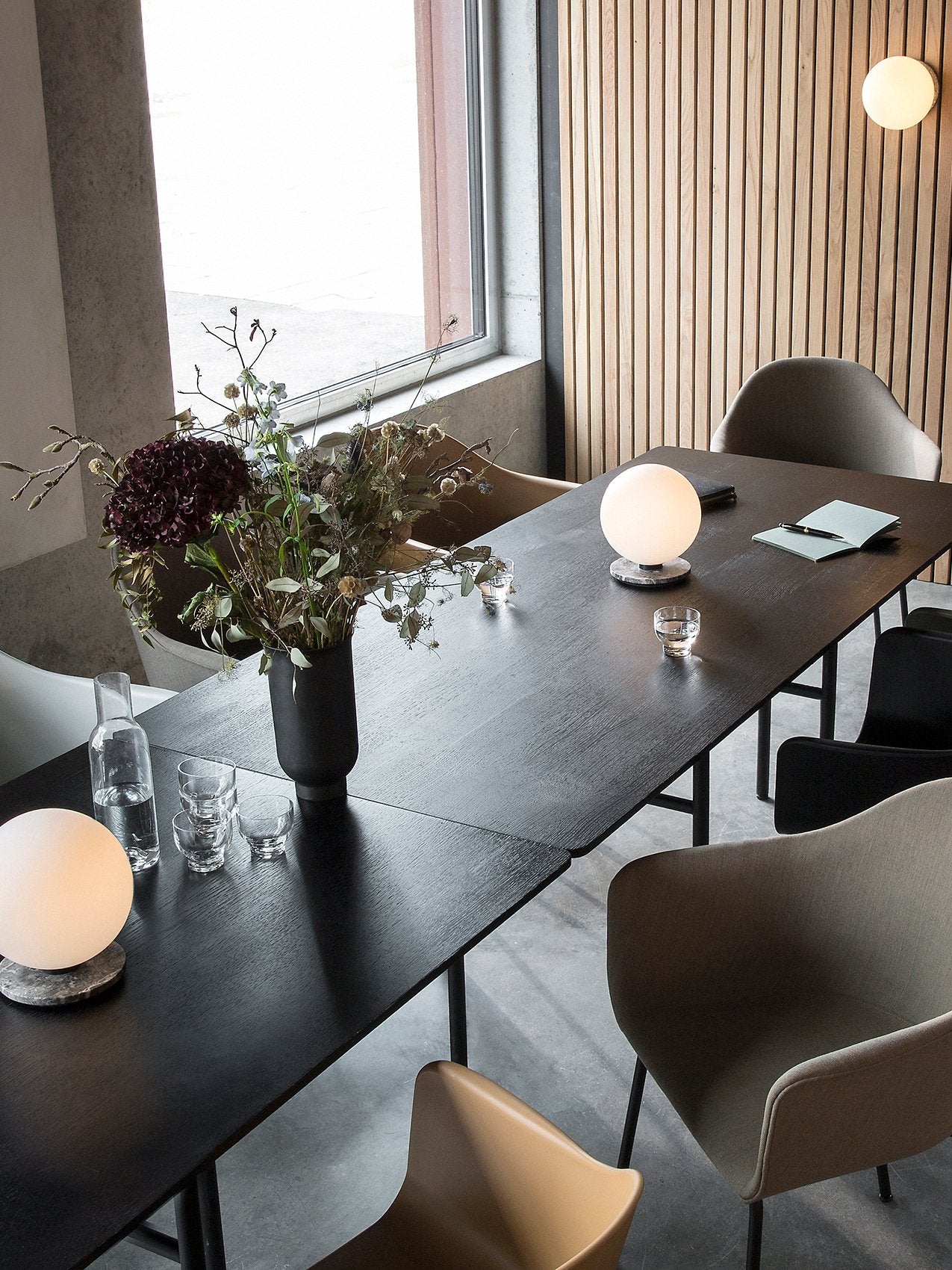 TR Bulb Table/Wall Lamp by Audo styled on a dining table in a bright restaurant setting – In Dubai by WSPR