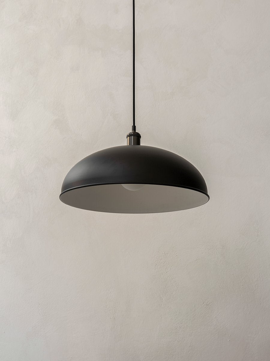Hubert Pendant Ø45 by Audo styled against a soft plaster wall, showing the matte black dome shade – In Dubai by WSPR