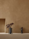 Kubus Vase Lolo by Audo styled on a plaster ledge with dark foliage – In Dubai by WSPR