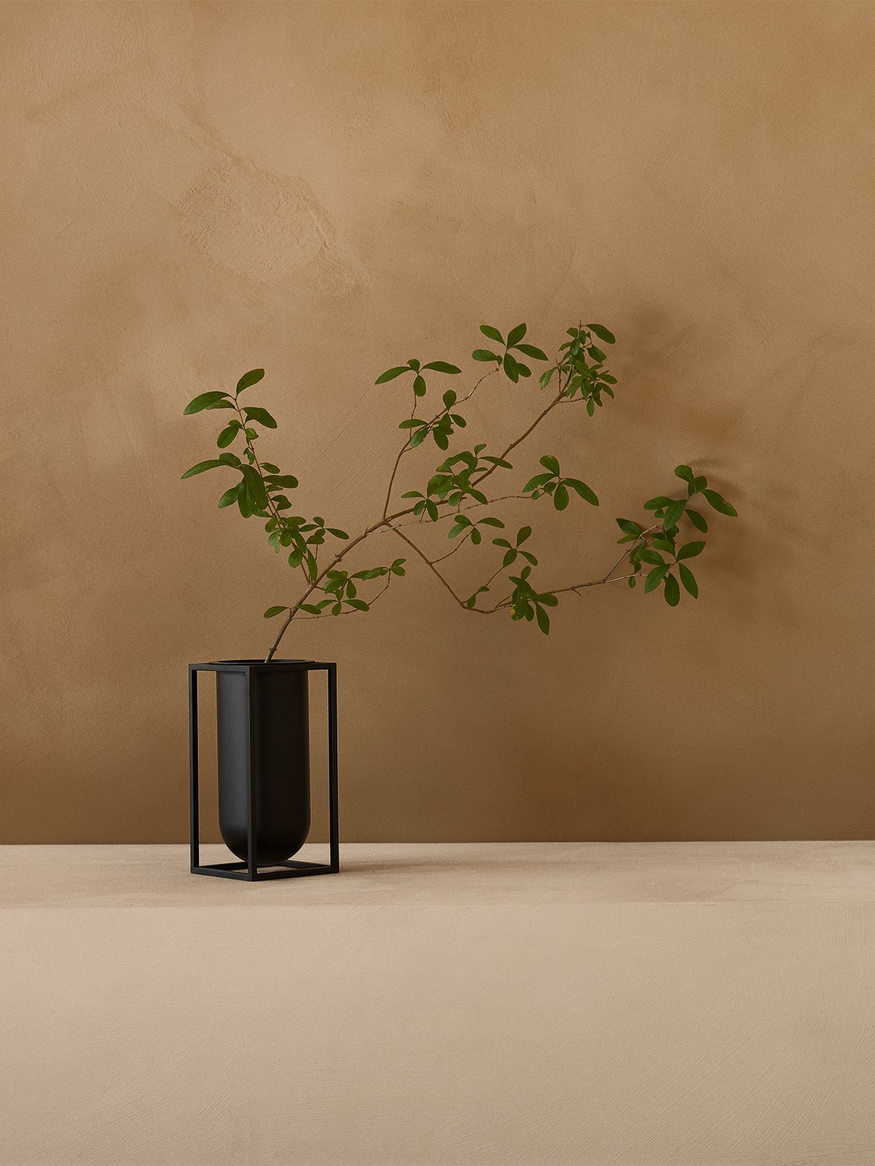 Kubus Vase Lolo by Audo styled in a warm plaster interior with green branches – In Dubai by WSPR