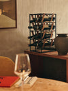 Umanoff Wine Rack by Audo styled on a wooden table beside a wine glass and a dark vase – In Dubai by WSPR