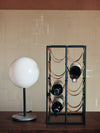 Umanoff Wine Rack by Audo styled on a dark console beside a round white table lamp – In Dubai by WSPR
