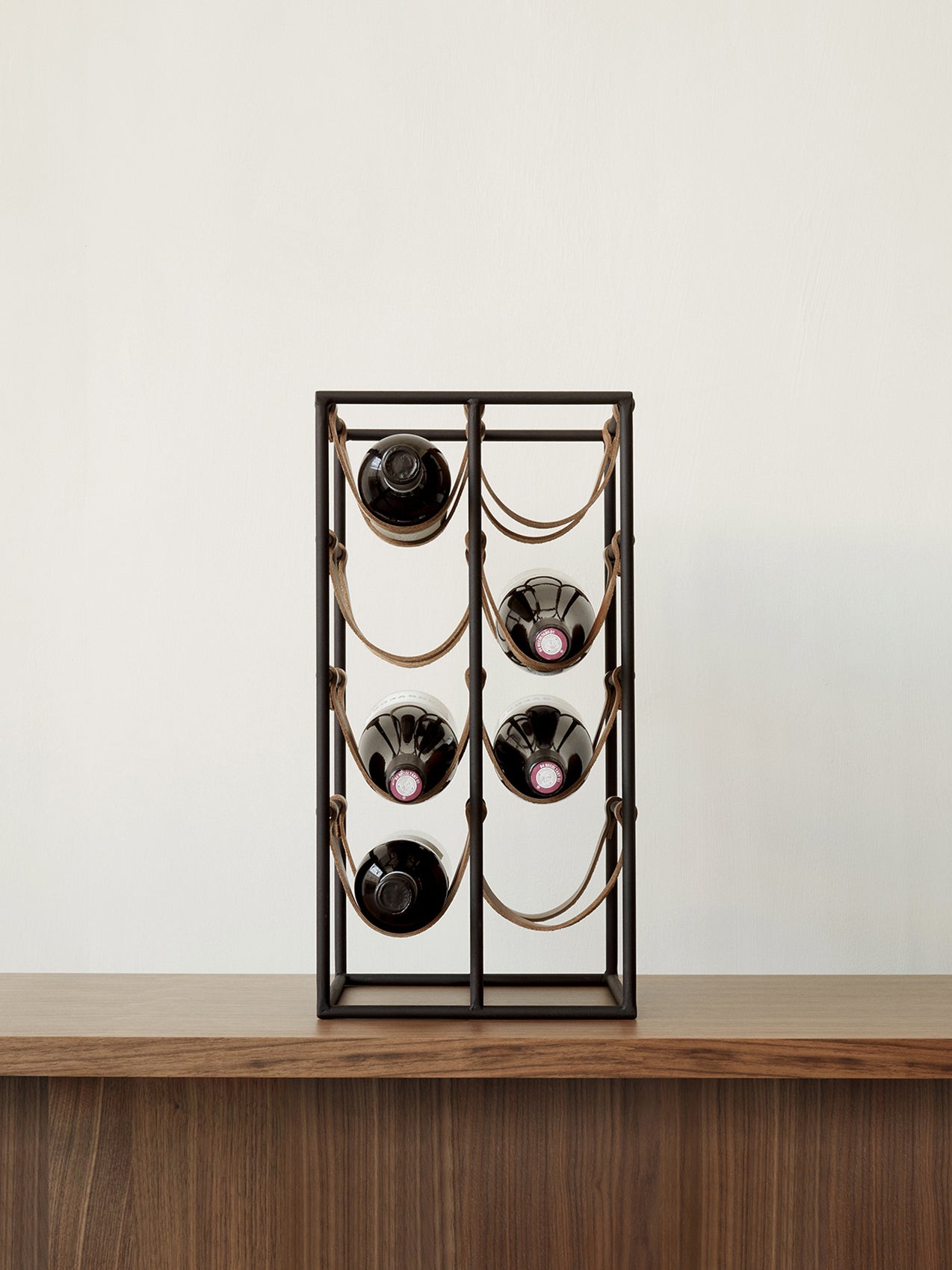 Umanoff Wine Rack by Audo holding wine bottles on a wooden sideboard – In Dubai by WSPR