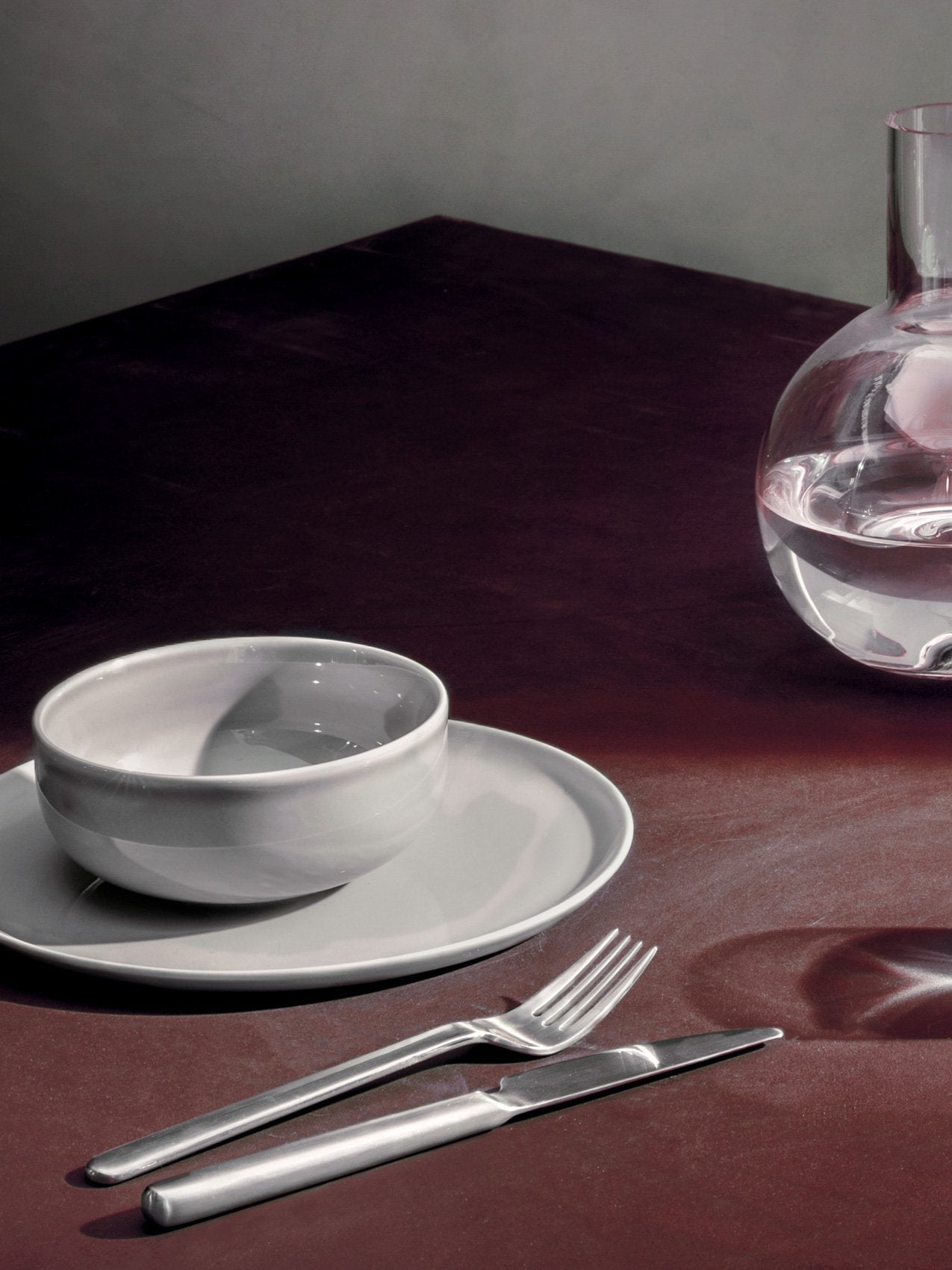 New Norm Flatware by Audo styled on a dark table with stoneware and a glass carafe – In Dubai by WSPR