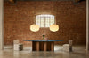 Baso Pendant Lamp by Miniforms styled as a pair above a long table in a brick hall – In Dubai by WSPR