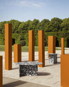Chap Coffee Table by Miniforms in Palladio Moro marble, styled in a garden among orange columns – In Dubai by WSPR