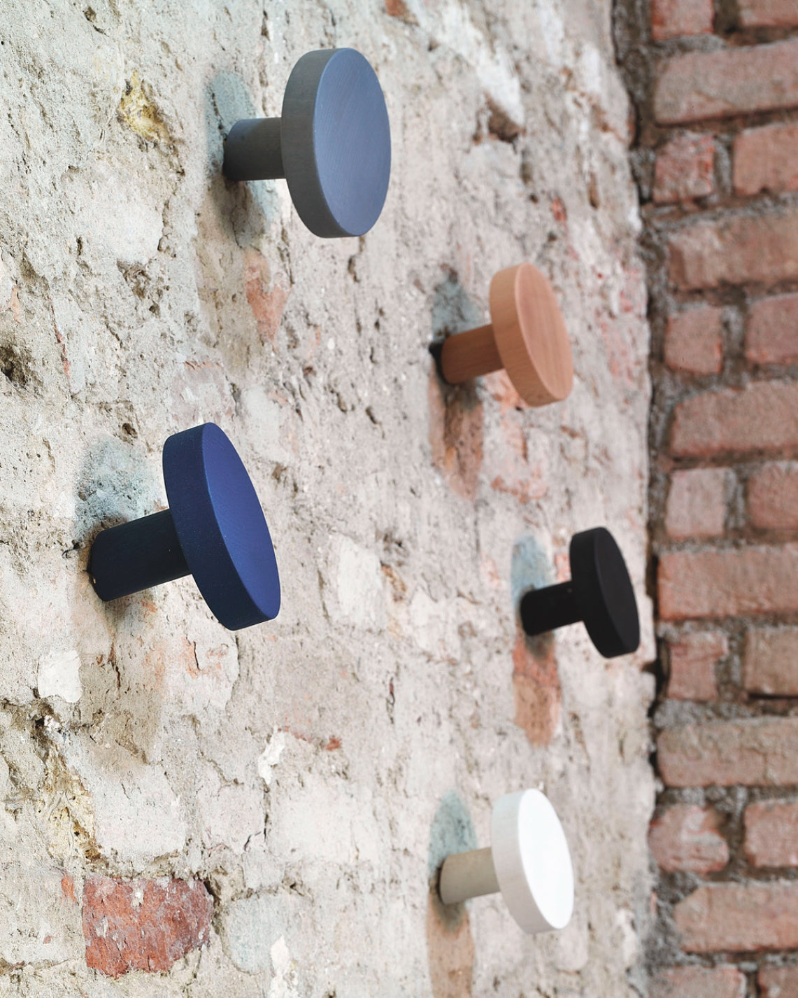 Chiodo Hanger by Miniforms styled on a rough brick wall in several finishes – In Dubai by WSPR