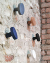 Chiodo Hanger by Miniforms styled on a rough brick wall in several finishes – In Dubai by WSPR