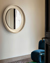 Coque Mirror by Miniforms in cream, styled in a hallway beside a doorway and a blue armchair – In Dubai by WSPR