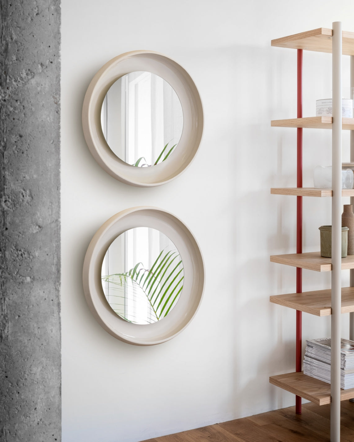Coque Mirror by Miniforms styled as a pair on a white wall beside timber shelving – In Dubai by WSPR