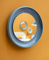Coque Mirror by Miniforms in blue-grey glazed ceramic, front view on an ochre wall – In Dubai by WSPR