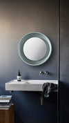 Coque Mirror by Miniforms in a soft green-grey finish, styled above a basin against a dark wall – In Dubai by WSPR