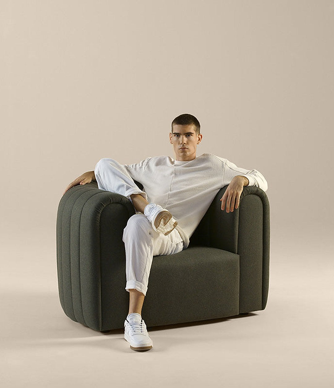 Core Armchair by Sancal in dark green, seated – In Dubai by WSPR