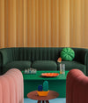 Core Armchair by Sancal in pink and red around a green sofa – In Dubai by WSPR