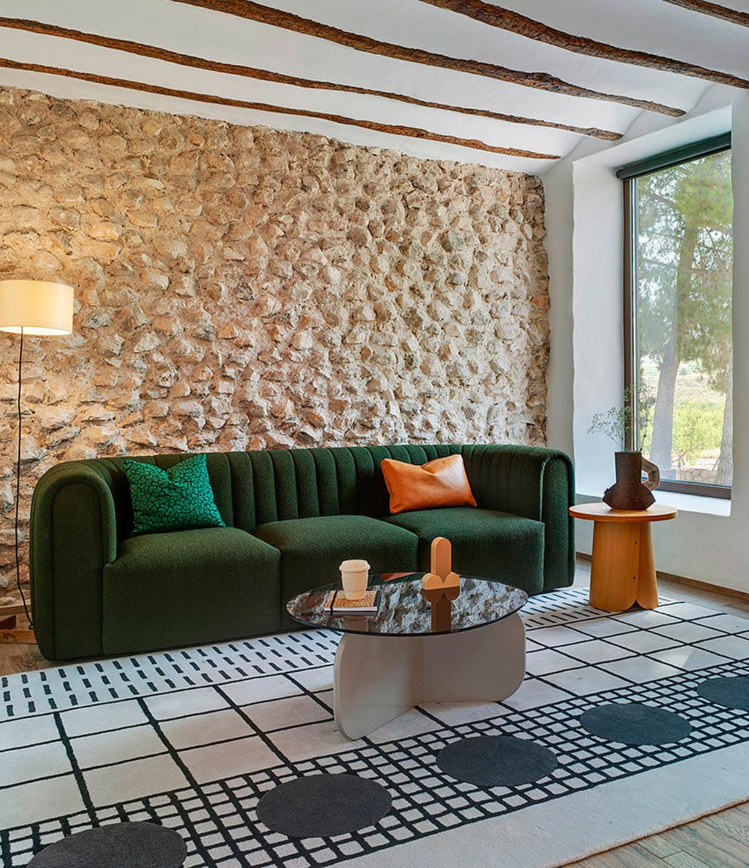 Core Sofa by Sancal in dark green against a stone wall – In Dubai by WSPR
