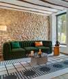 Core Sofa by Sancal in dark green against a stone wall – In Dubai by WSPR