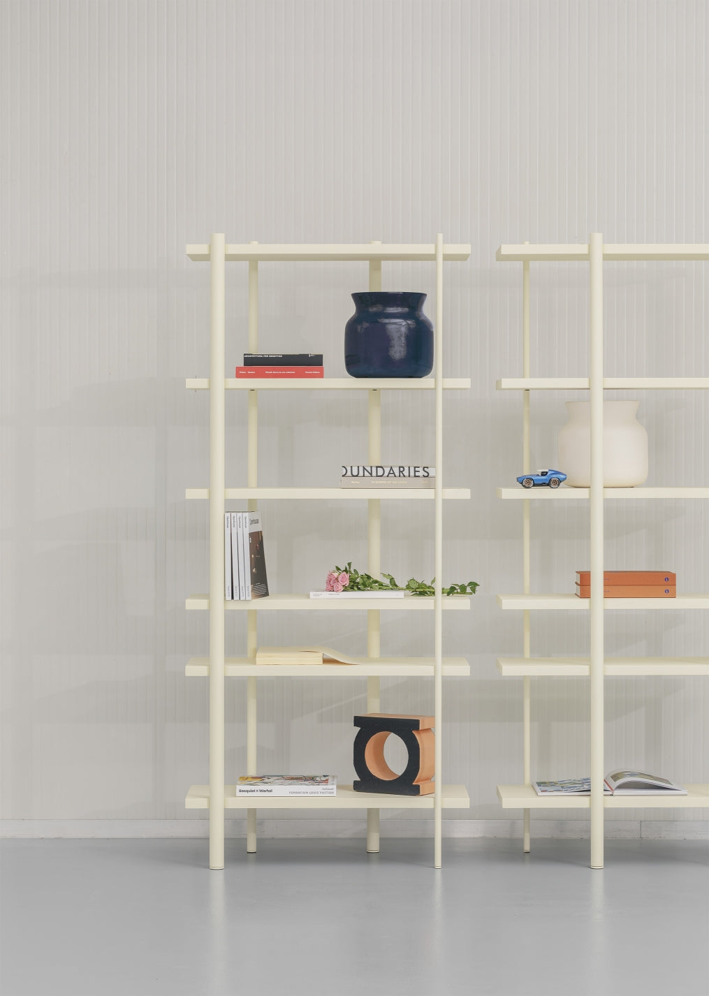 Cuoppo Vase by Miniforms in Blu baked clay, styled on a cream shelving unit with books – In Dubai by WSPR