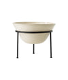 Daiza Planter by Audo in glazed ivory stoneware on a four-legged black iron stand, wide low size, front view – In Dubai by WSPR