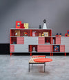 Estante Acoustic Shelving by Sancal wall of units in red and grey with a lounge chair – In Dubai by WSPR