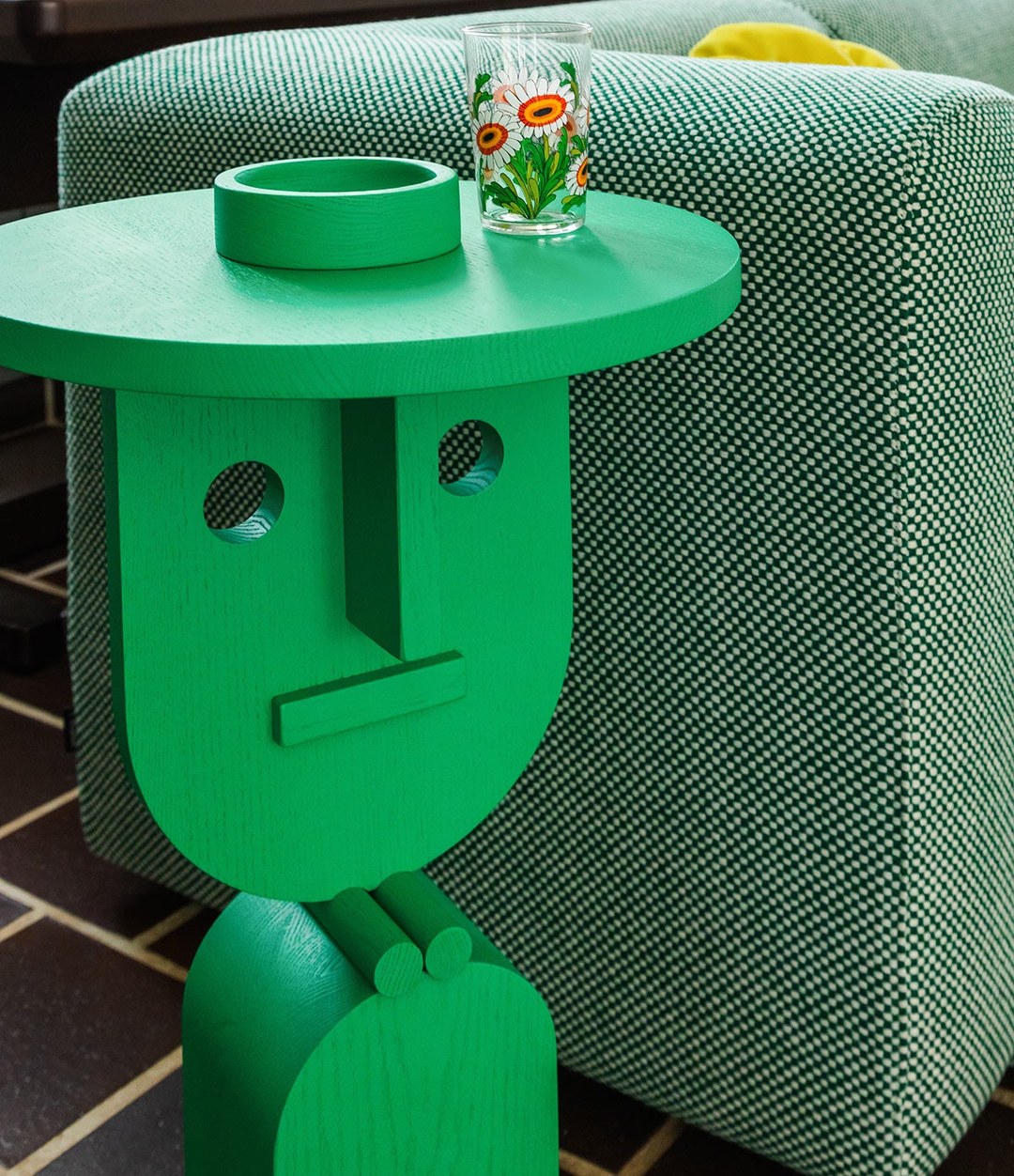 Faces Side Table by Sancal in green beside a sofa – In Dubai by WSPR