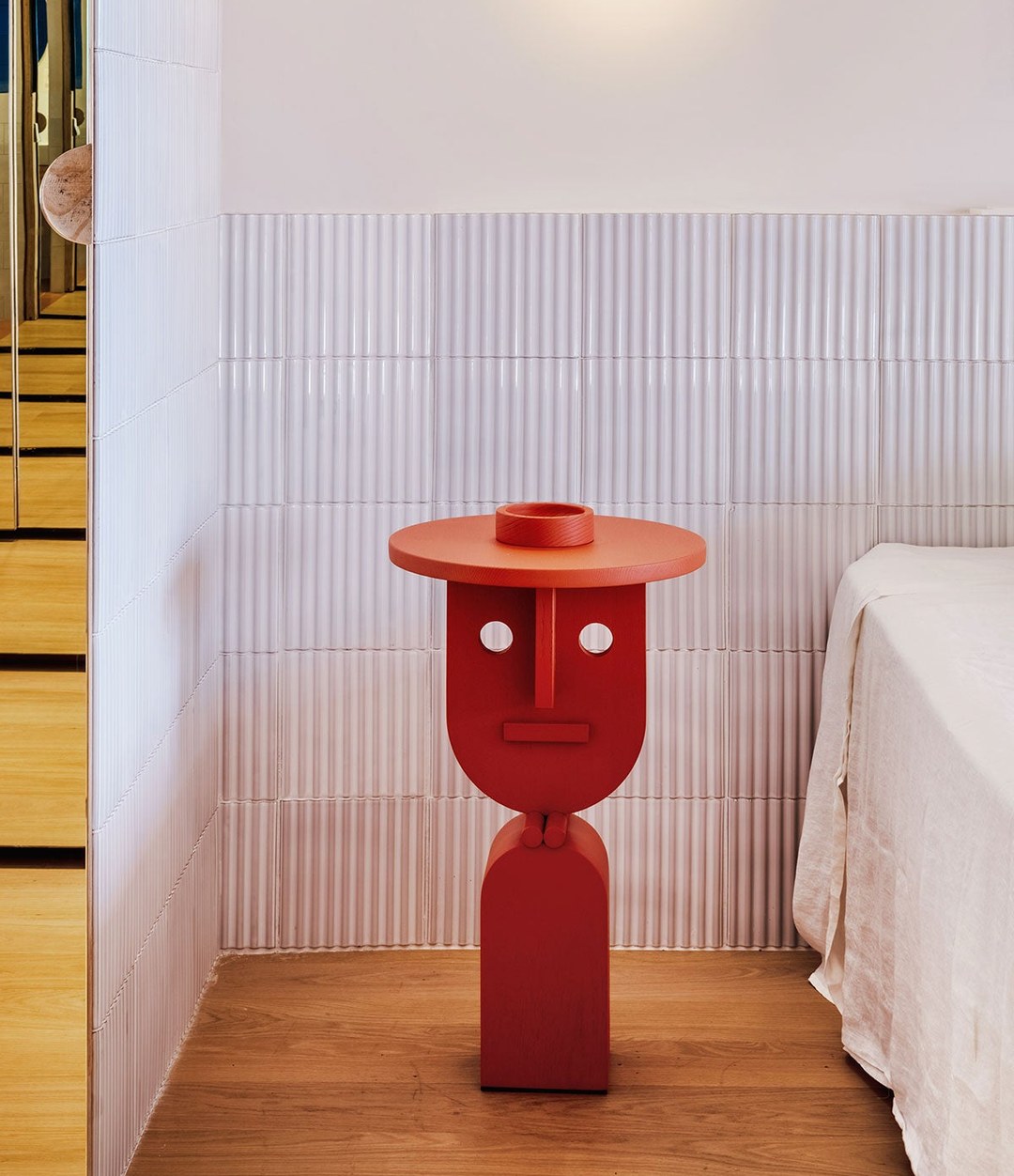 Faces Side Table by Sancal in red by a bed – In Dubai by WSPR