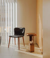 Faces Side Table by Sancal in dark oak beside a dining chair – In Dubai by WSPR