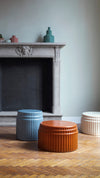 Kolos Coffee Table by Miniforms styled by a fireplace, in blue, orange and cream ceramic – In Dubai by WSPR