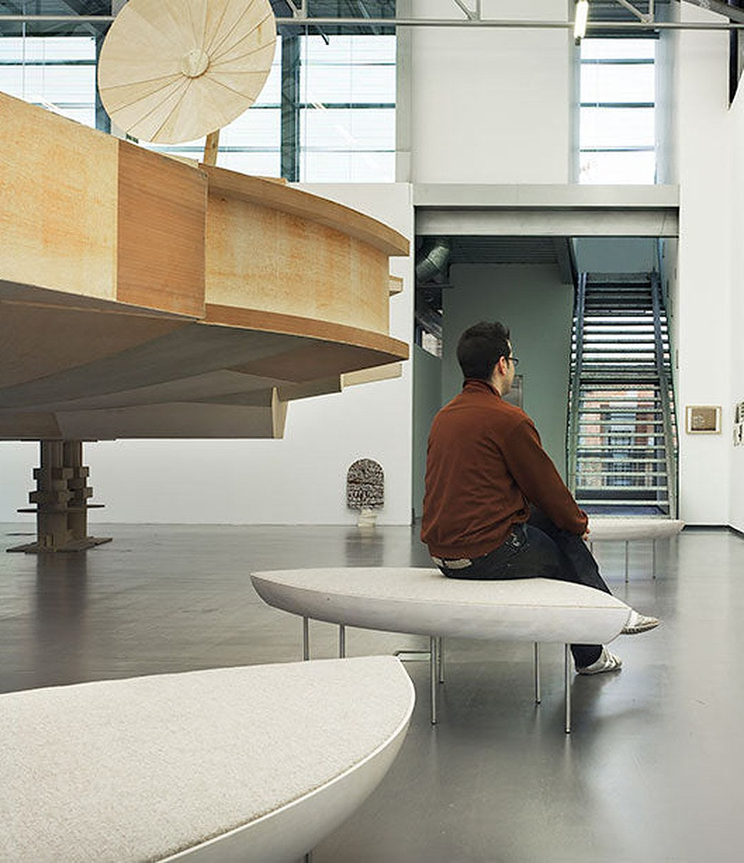 Konoha Bench by Sancal in a gallery with a visitor – In Dubai by WSPR