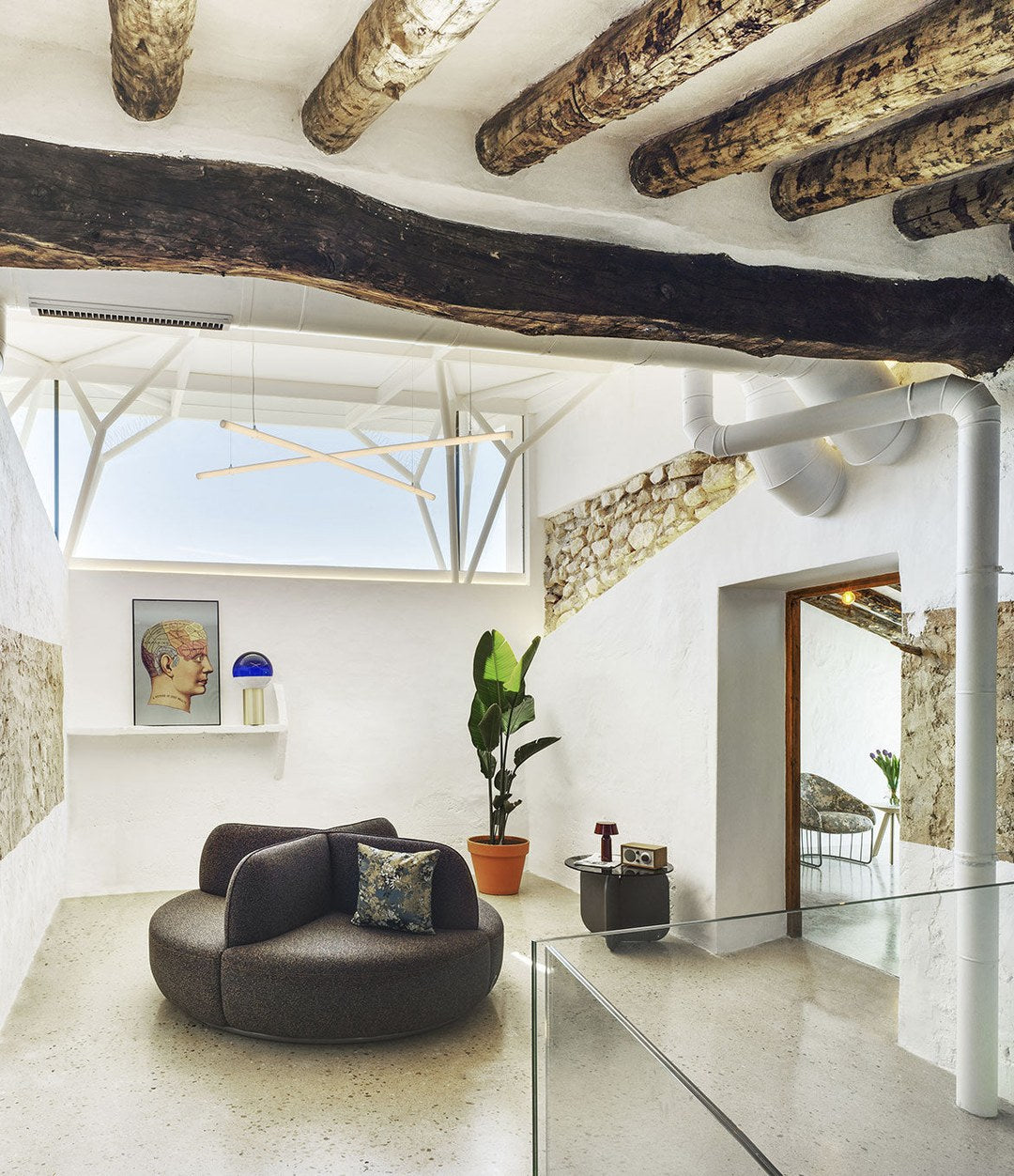 La Isla Bench by Sancal round in dark grey in a whitewashed hall – In Dubai by WSPR