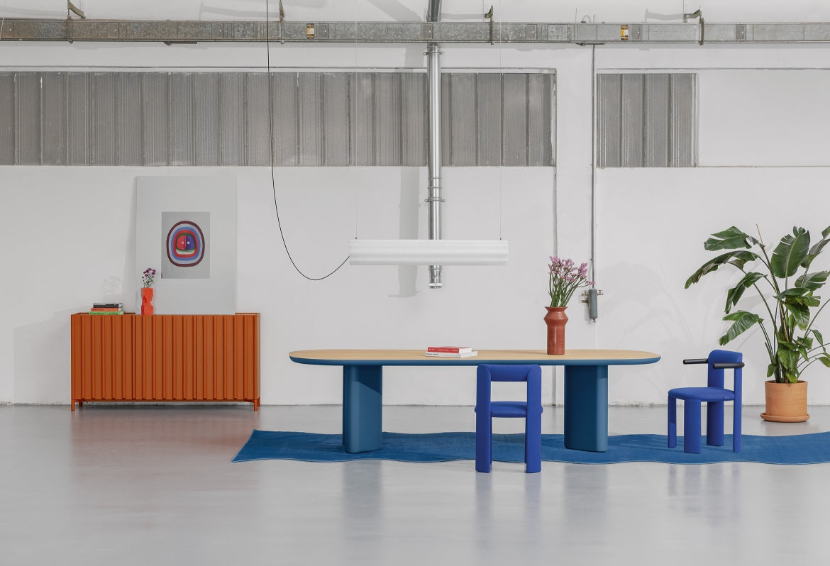 Lucerama Pendant by Miniforms styled above a wooden table with blue chairs in a studio – In Dubai by WSPR