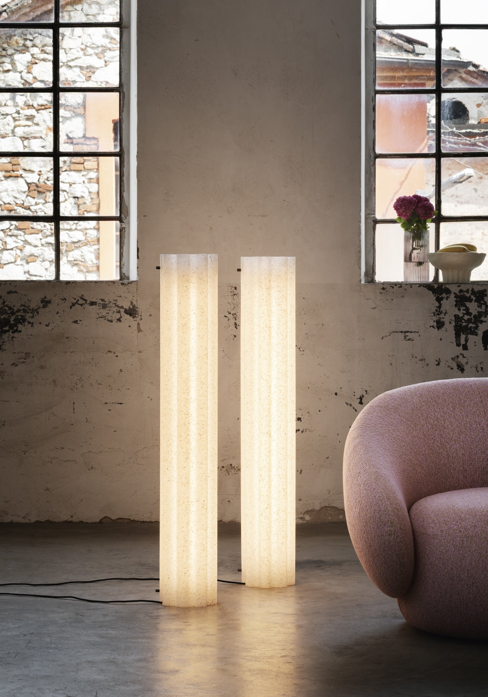 Lucerama Floor Lamp by Miniforms styled as a pair of lit tubes beside a pink armchair – In Dubai by WSPR
