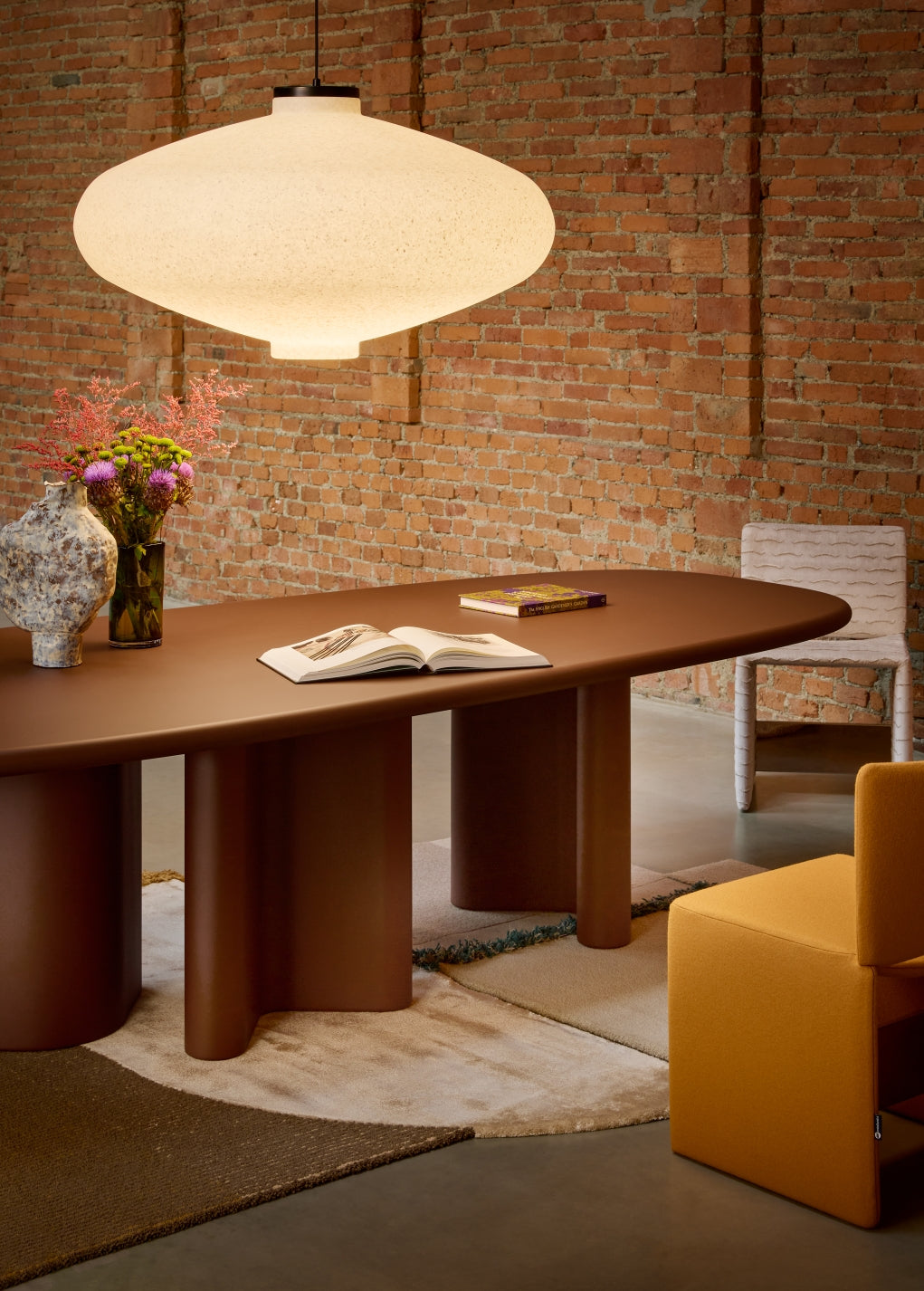 Muna Pendant by Miniforms in White Moon, styled above a dining table against a brick wall – In Dubai by WSPR
