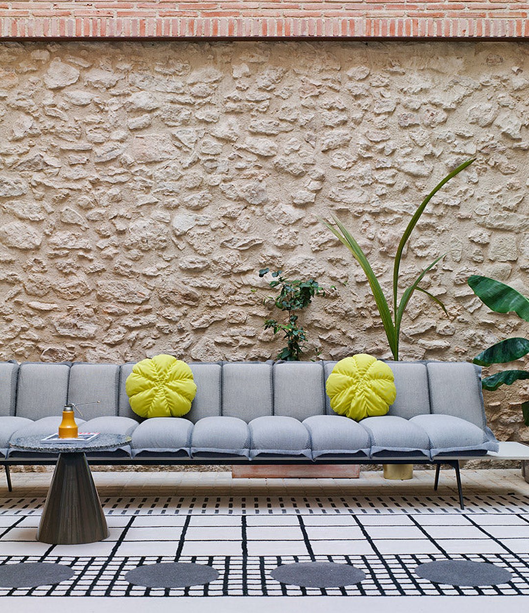 Next Stop Sofa by Sancal in grey with yellow cushions in a courtyard – In Dubai by WSPR