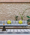 Next Stop Sofa by Sancal in grey with yellow cushions in a courtyard – In Dubai by WSPR