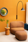 Ozz Wall Lamp by Miniforms in black, styled on an orange wall above a lounge chair – In Dubai by WSPR