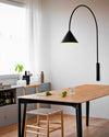 Ozz Wall Lamp by Miniforms in black, styled above a timber dining table – In Dubai by WSPR