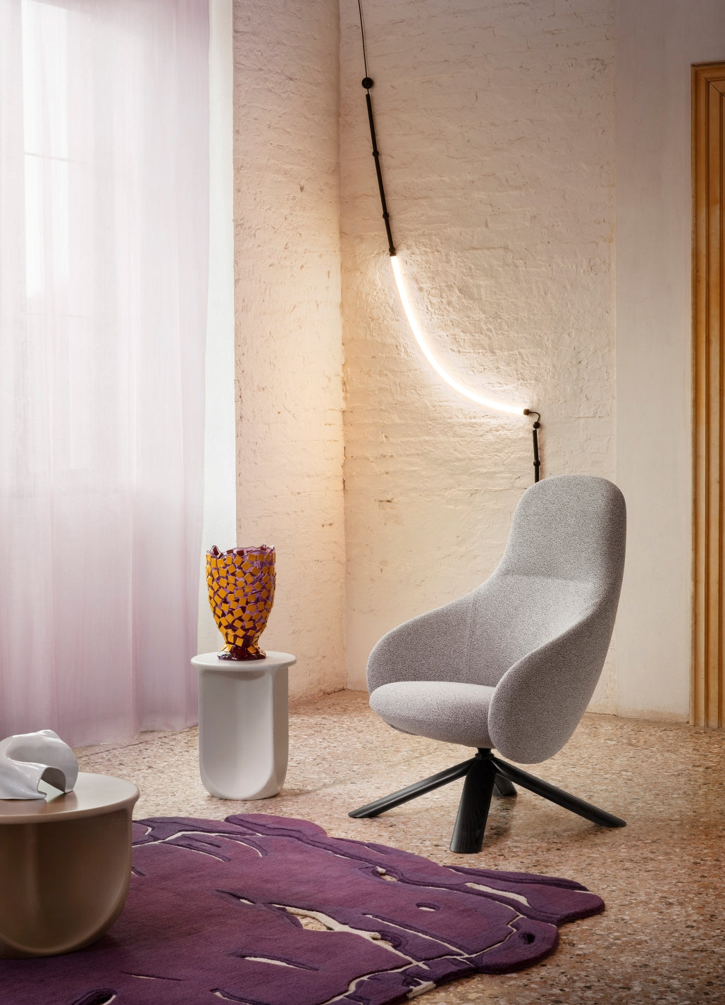 Pinto Coffee Table by Miniforms in a pale concrete finish beside a grey armchair – In Dubai by WSPR