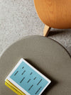 Pinto Coffee Table by Miniforms in a grey concrete finish, detail of the top with a book – In Dubai by WSPR