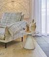 Pion Side Table by Sancal in white beside a checked sofa – In Dubai by WSPR