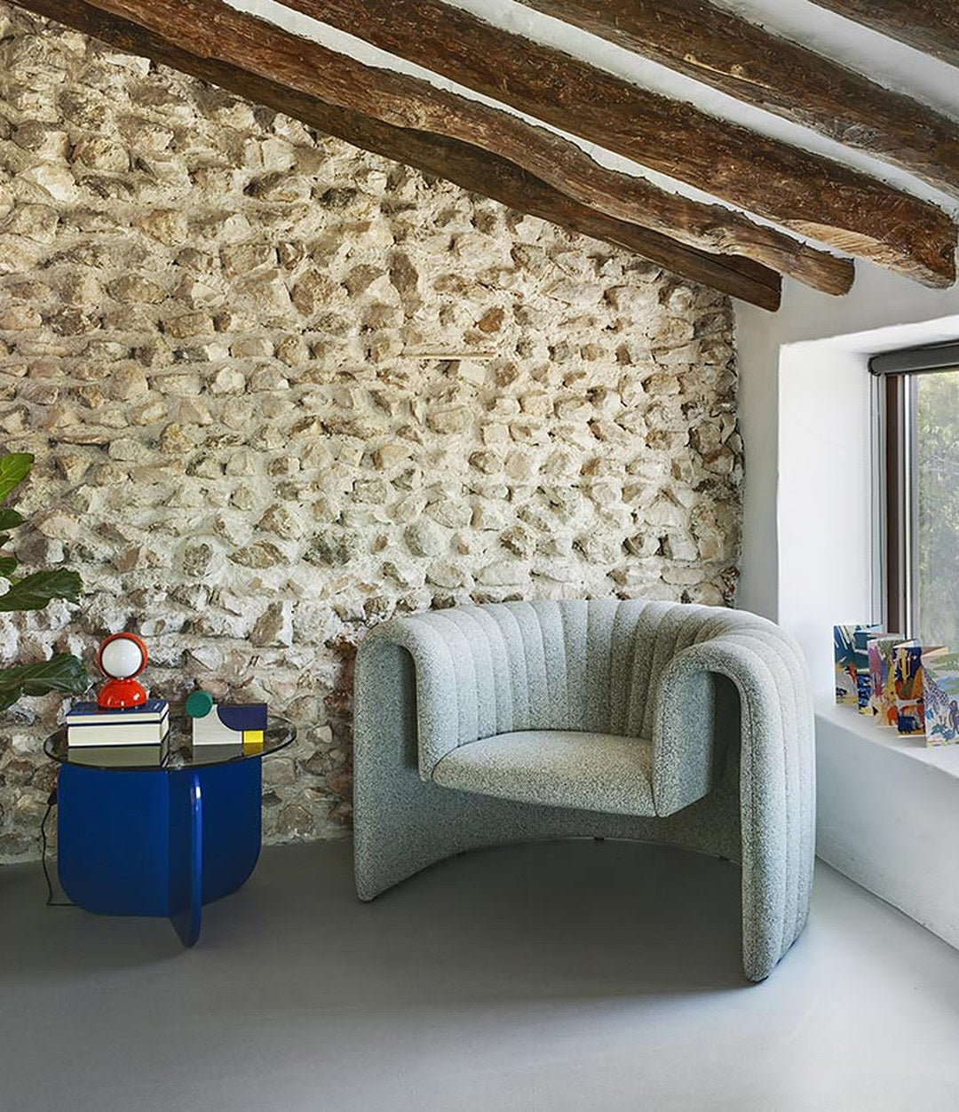 Remnant Sofa by Sancal armchair in pale blue by a stone wall – In Dubai by WSPR