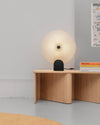Rificolona Desk Lamp by Miniforms styled on a wooden console beside a stack of books – In Dubai by WSPR
