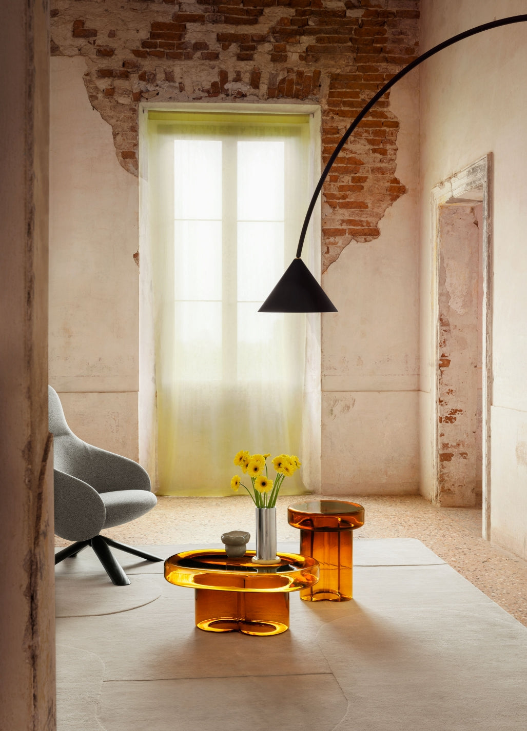 Soda Oval Coffee Table by Miniforms styled in amber blown glass in a room with exposed brick and an arched lamp – In Dubai by WSPR