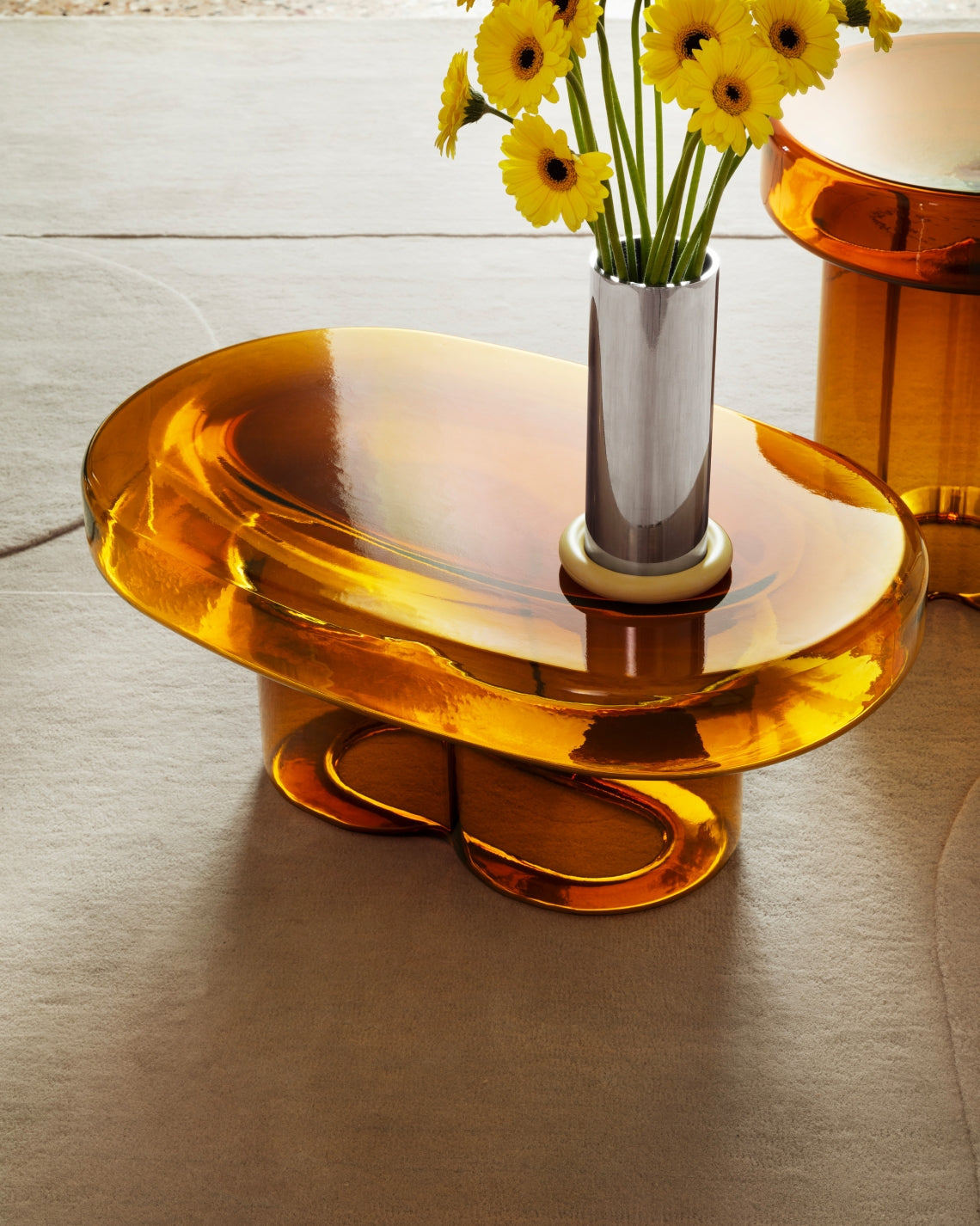 Soda Oval Coffee Table by Miniforms styled in amber blown glass with a vase of yellow flowers – In Dubai by WSPR