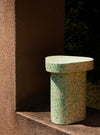 Superpop Coffee Table by Miniforms in a light speckled finish beside a terracotta wall, side view – In Dubai by WSPR