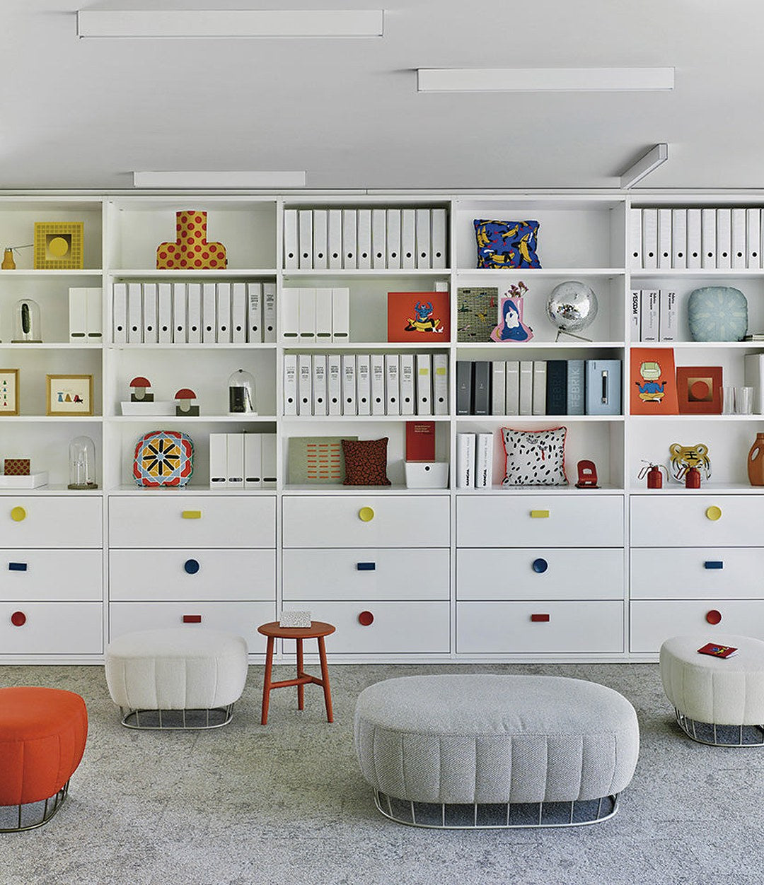 Tonella Pouf by Sancal in grey and red in front of shelving – In Dubai by WSPR
