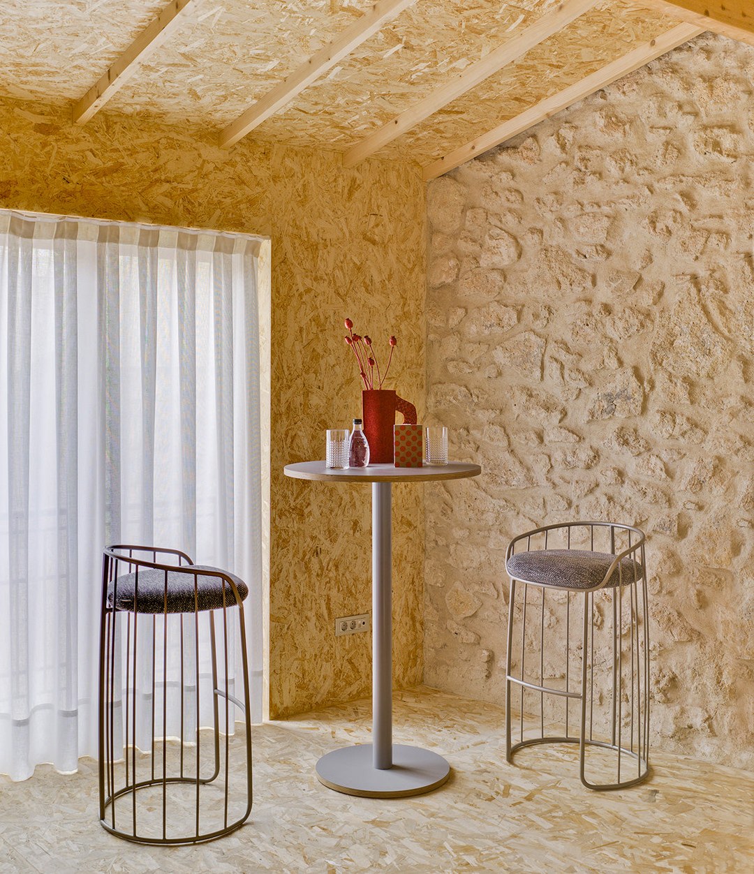 Tonella Stool by Sancal by a high table against a stone wall – In Dubai by WSPR